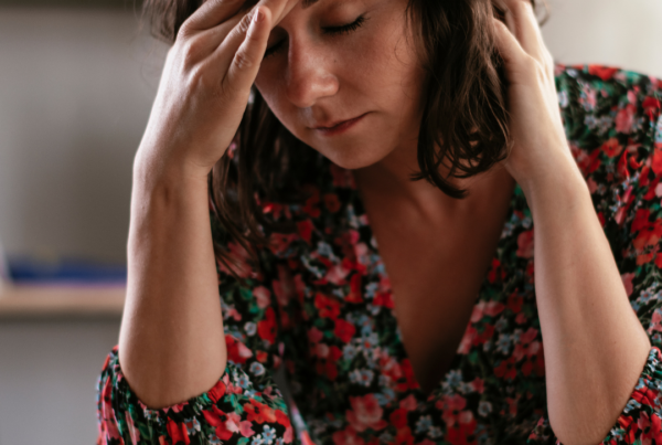 Woman holding head while working at desk