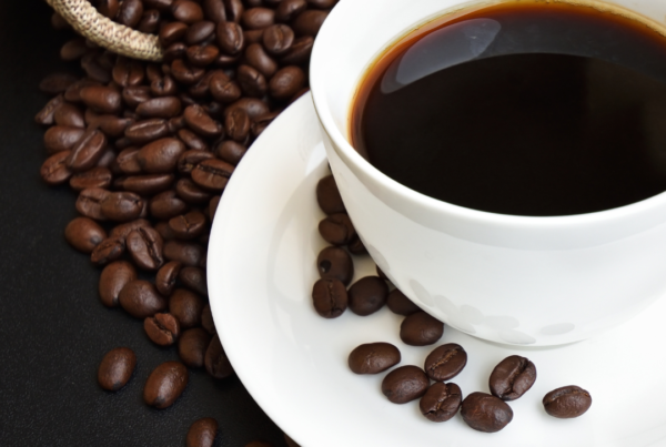 Cup of black coffee with roasted beans