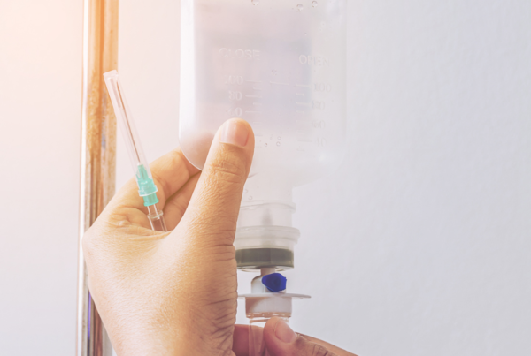 Hands adjusting intravenous IV drip in hospital