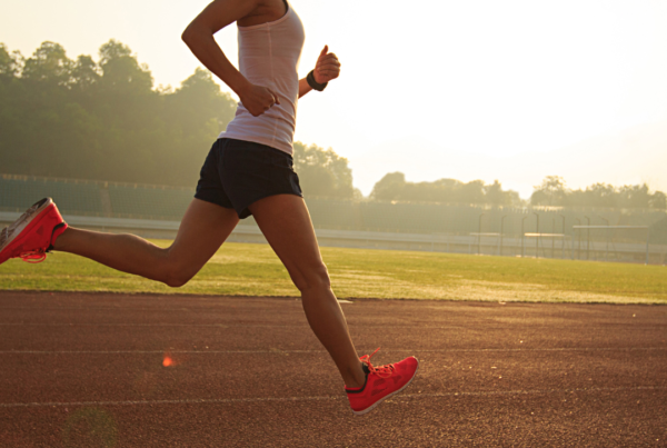 Woman running on track at sunrise